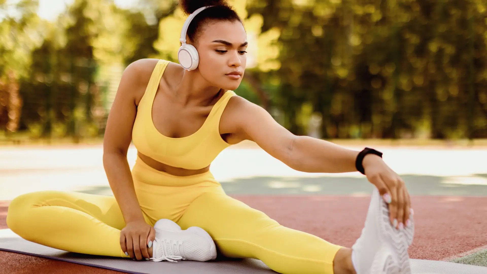 Uma mulher utiliza um fone enquanto se exercita ao ar livre
