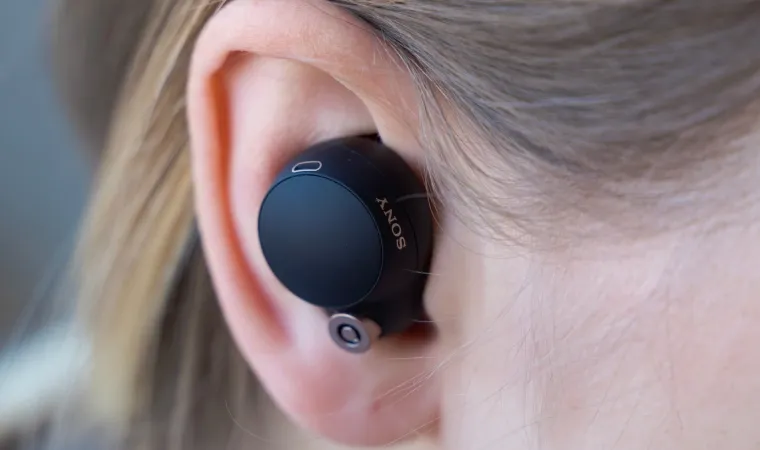 Mulher com um fone com cancelamento de ruído na orelha