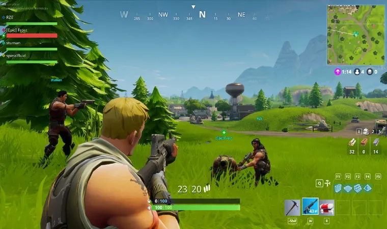 Imagem do jogo Fortnite com um personagem segurando uma arma enquanto seu companheiro de time levanta um companheiro caído em meio a um campo aberto 