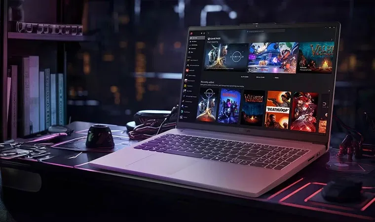 Foto do notebook gamer Lenovo Legion 5i em cima de uma mesa exibindo um menu com vários jogos instalados na tela como Starfield, Redfall, Valheim, Deathloop, Persona 5 Royal e mais 