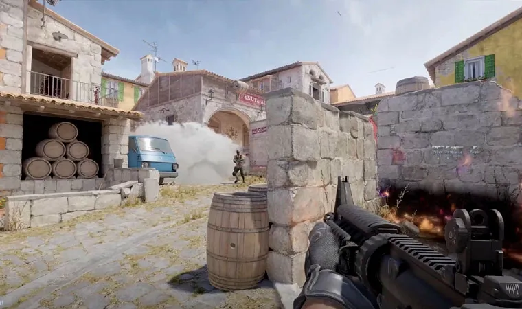 Imagem do jogo Counter-Strike 2 em primeira pessoa exibindo um personagem segurando uma arma enquanto mira em um oponente que acabou de sair de uma cortina de fumaça 