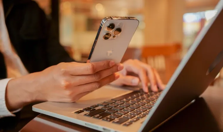 Uma pessoa mostra detalhes das câmeras de um celular modelo iPhone 14 Pro