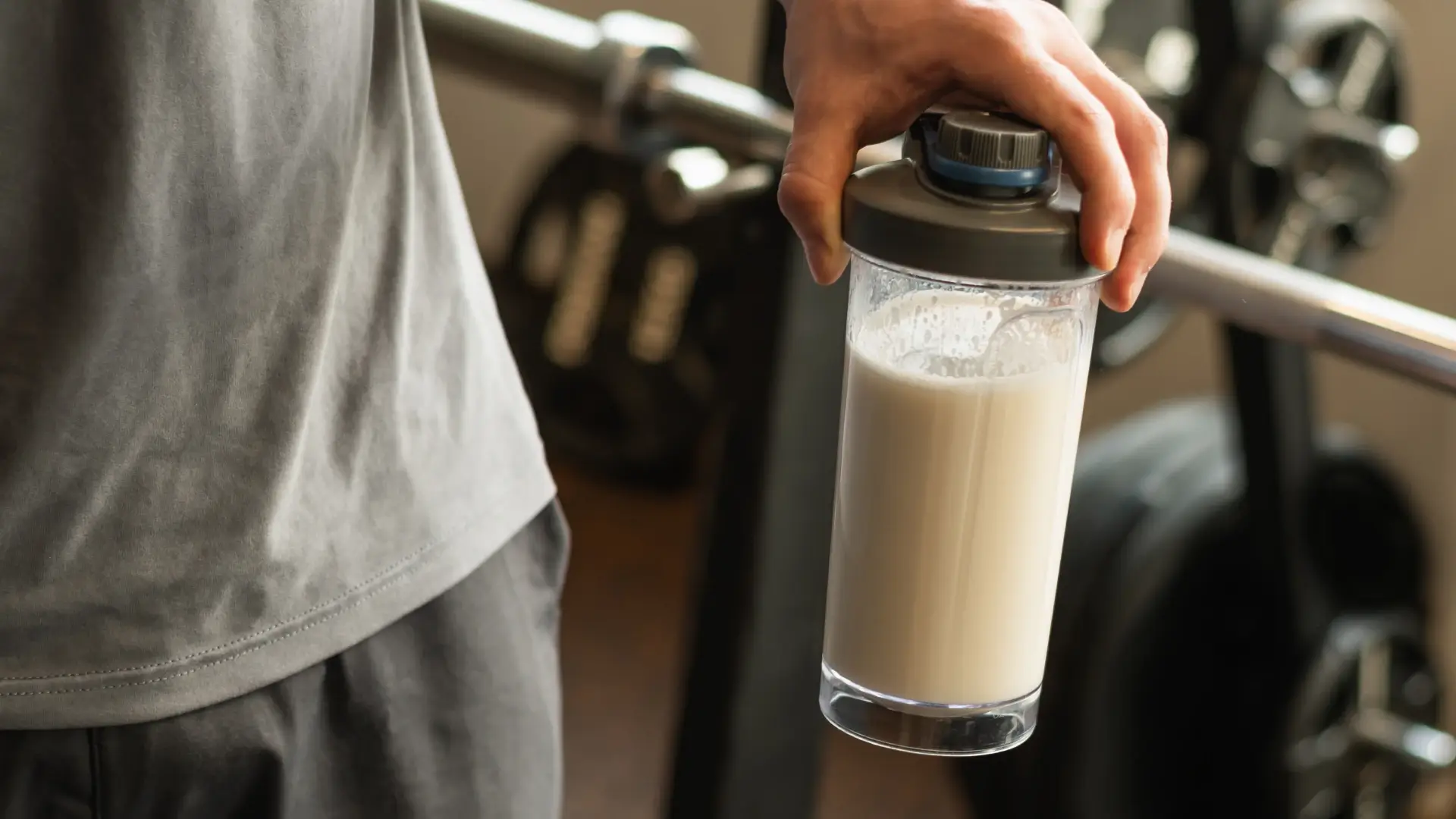 Um homem segurando um shake de whey protein