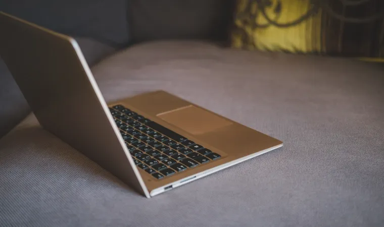 Imagem mostra notebook Lenovo em cima de uma cama