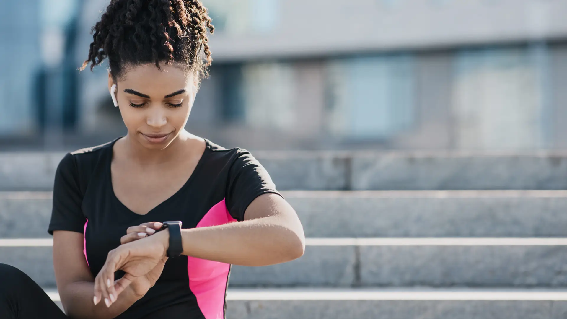 Uma pessoa está parada mexendo em um relógio