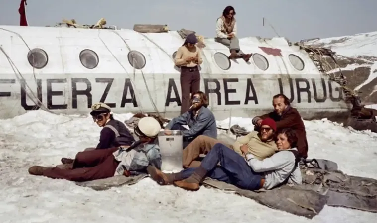  capa do filme A Sociedade da Neve mostrando sobreviventes ao lado dos destroços de um avião nos Andes 