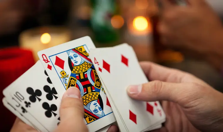 Mãos segurando cartas de baralho