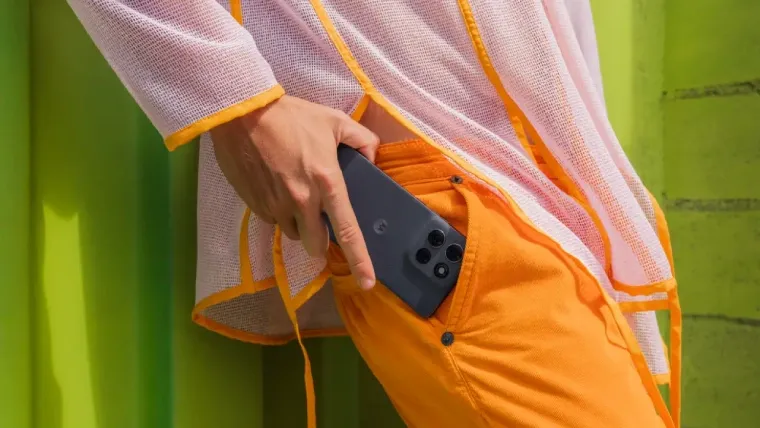 Uma pessoa está com um celular próximo do bolso