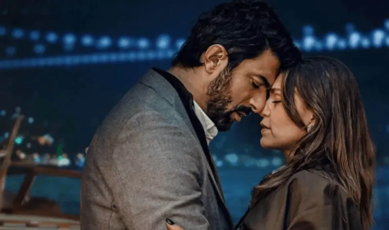 divulgação da novela turca Berço de Ouro, com Osman e Nihal se abraçando em uma cena romântica noturna com luzes da cidade ao fundo. 