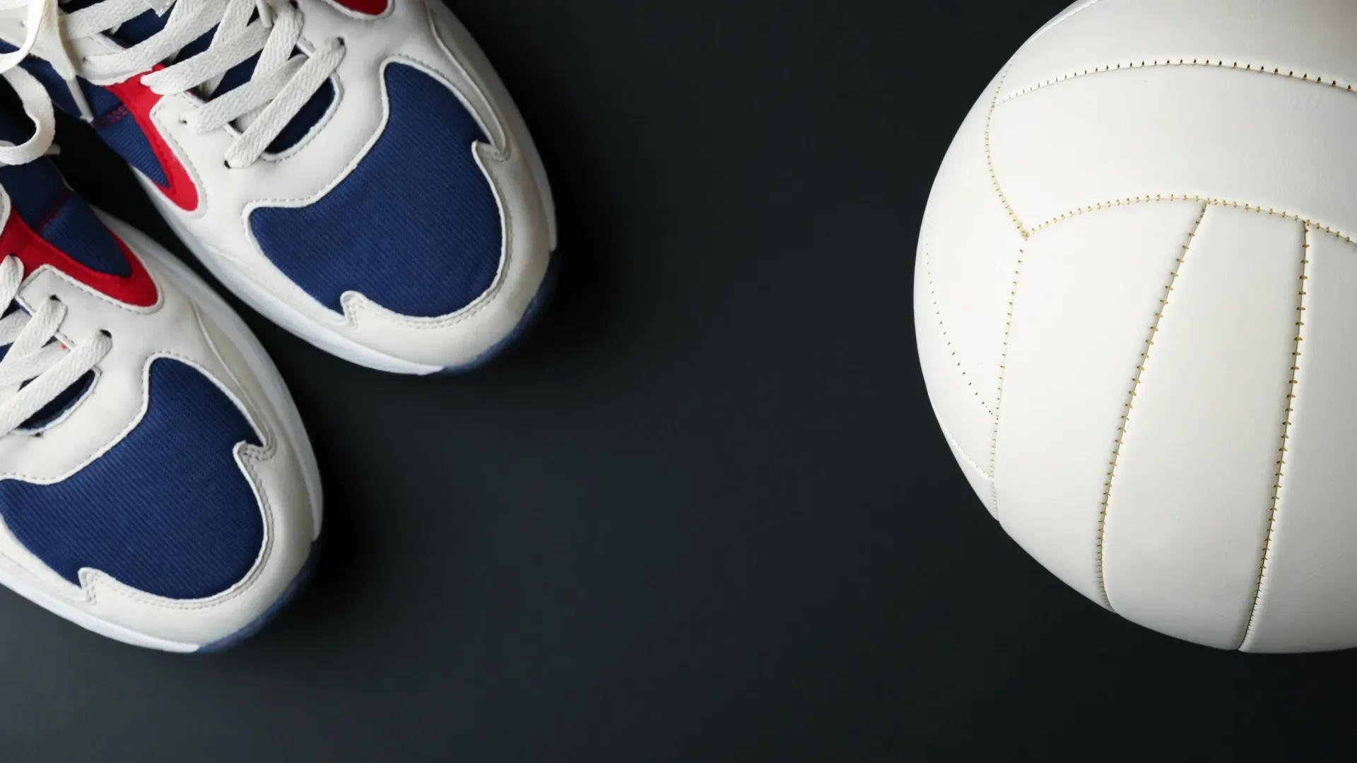 Imagem de um tênis ao lado de uma bola de vôlei