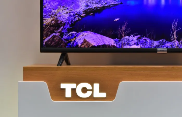 Imagem de uma logo em LED da TCL em um hack com uma TV da marca em cima