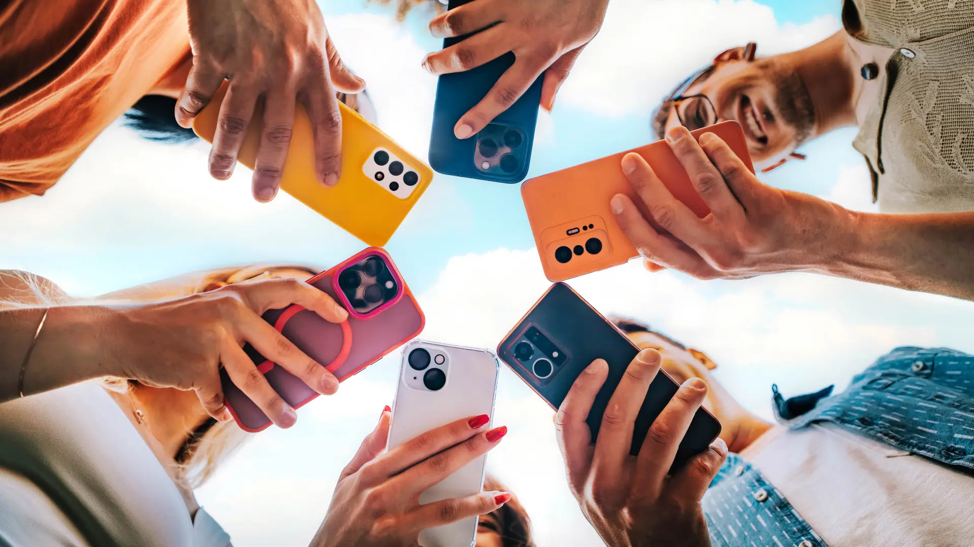 Diversas pessoas com celulares nas mãos fazem um círculo
