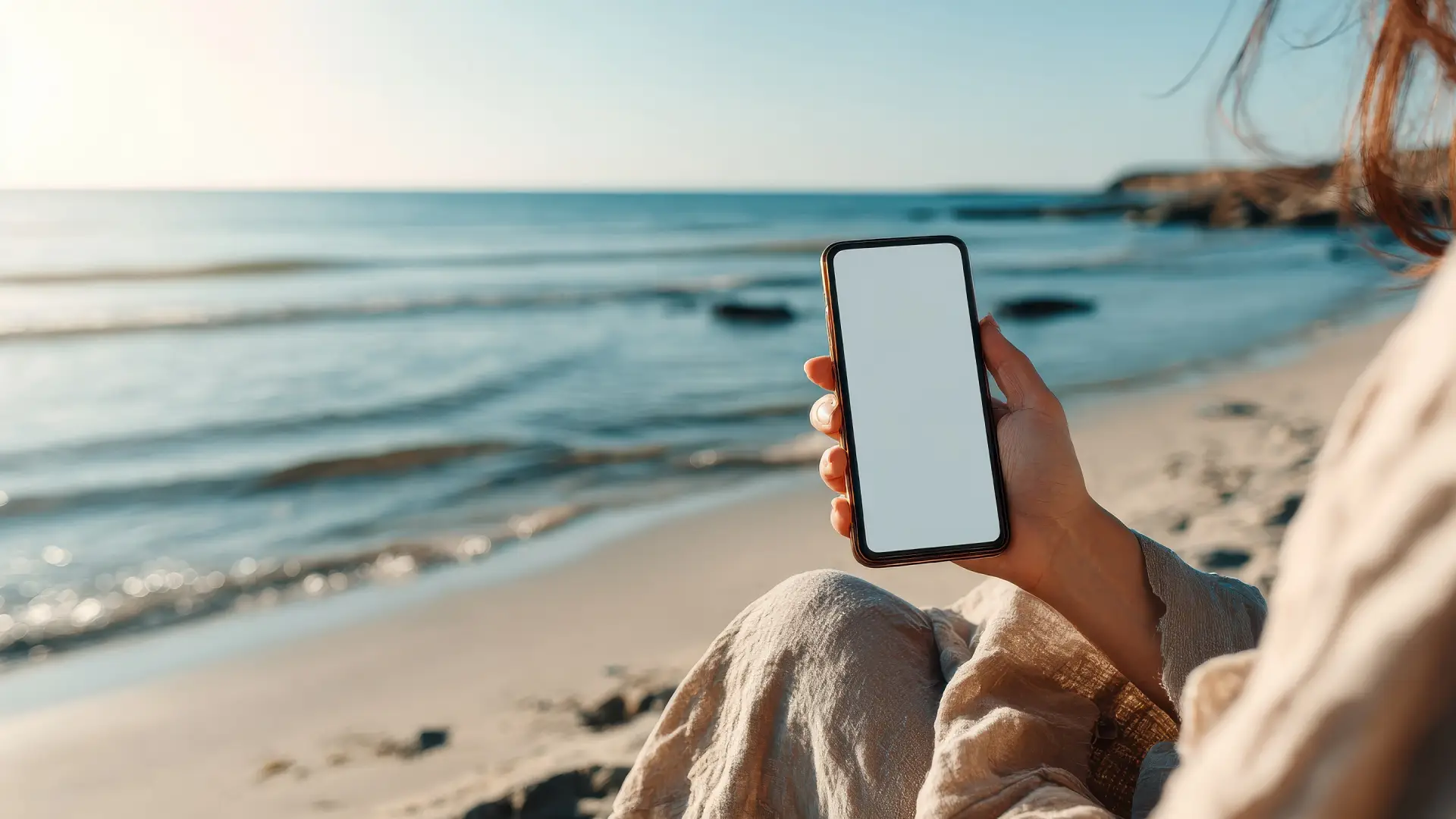 Mulher na praia usando um celular à prova d’água