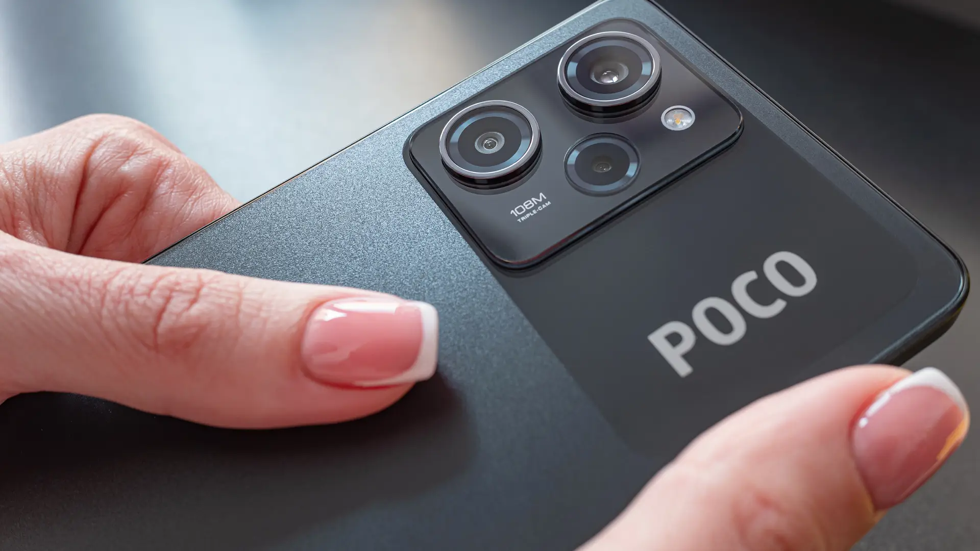 Imagem mostra detalhes de um Pocophone sendo segurado por duas mãos