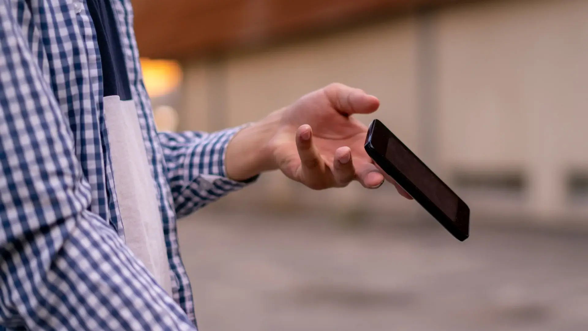 Imagem de um homem deixando um celular cair