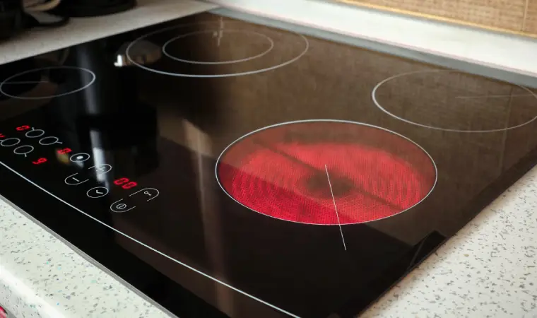 Imagem de uma mulher acendendo um fogão.