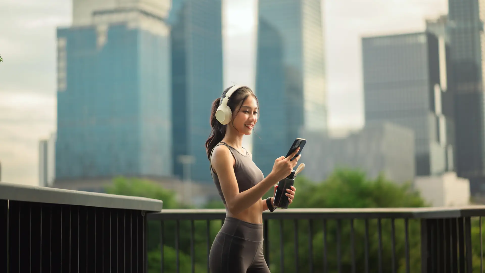 Uma mulher está olhando para o celular na rua