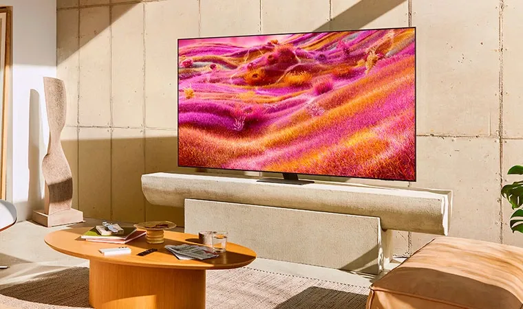 Imagem da Smart TV Neo QLED 43" Samsung 43QN90F em uma sala bem iluminada exibindo um campo colorido com tons de rosa e amarelo em sua grama 