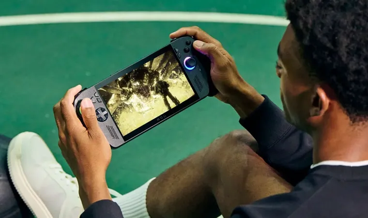 Imagem de um homem jogando no ROG Xbox Ally X enquanto segura uma bola de futebol com o pé    