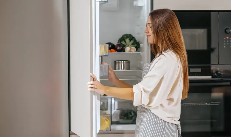 Mulher buscando por alimentos na geladeira
