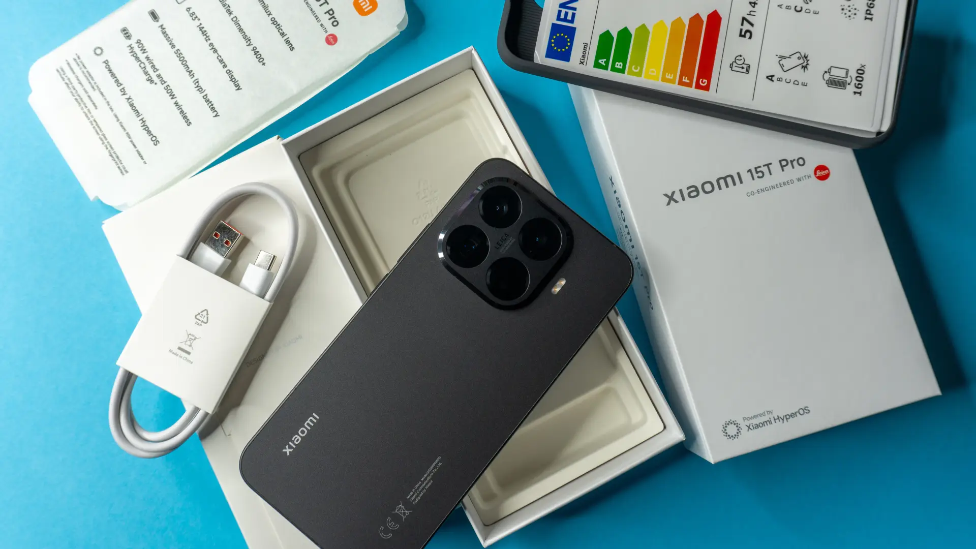 Imagem mostra a caixa de um celular da Xiaomi, ao lado de carregador, papel e uma capa protetora do celular