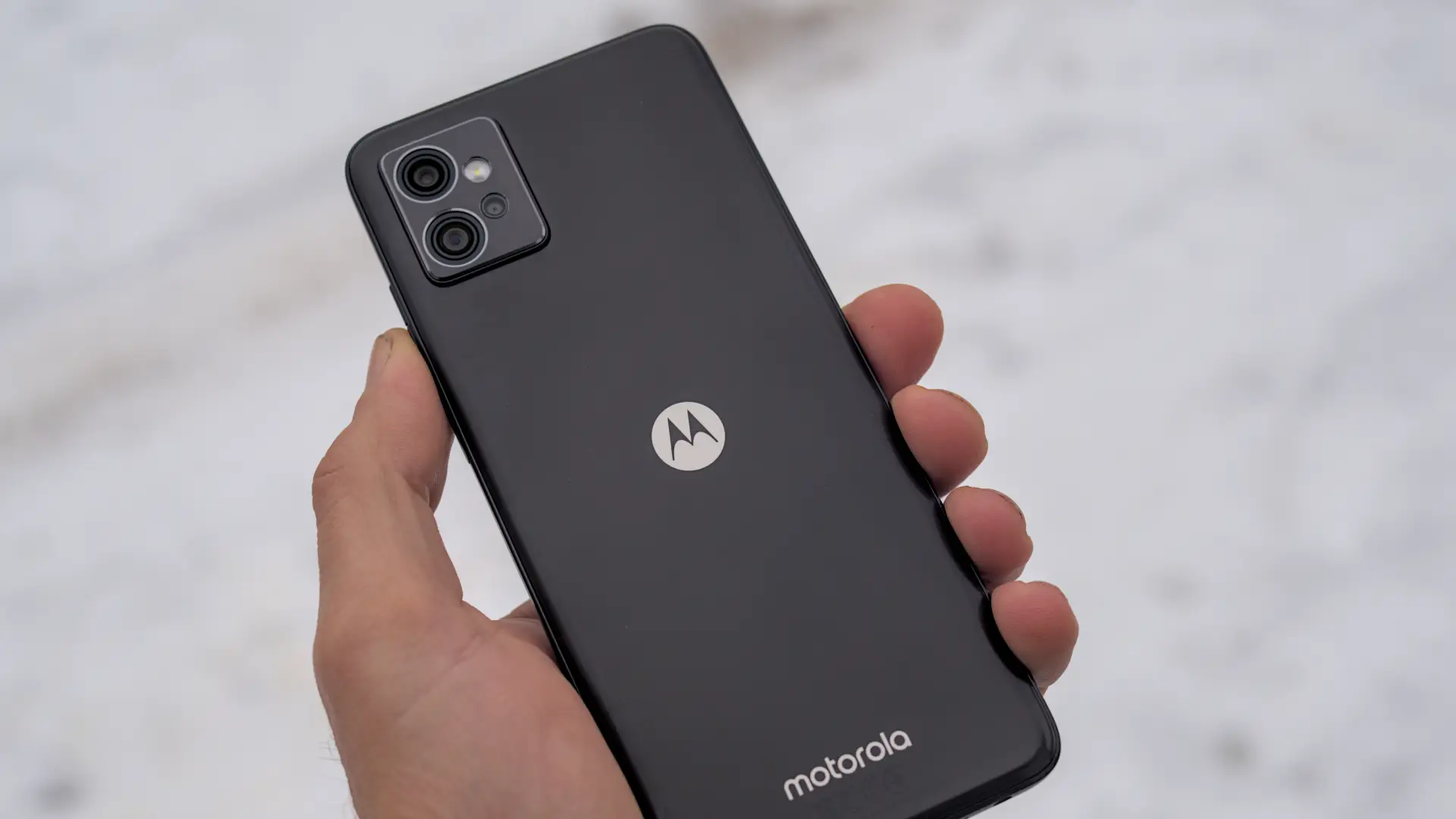 Imagem de uma pessoa segurando um celular Moto G com a traseira virada para cima