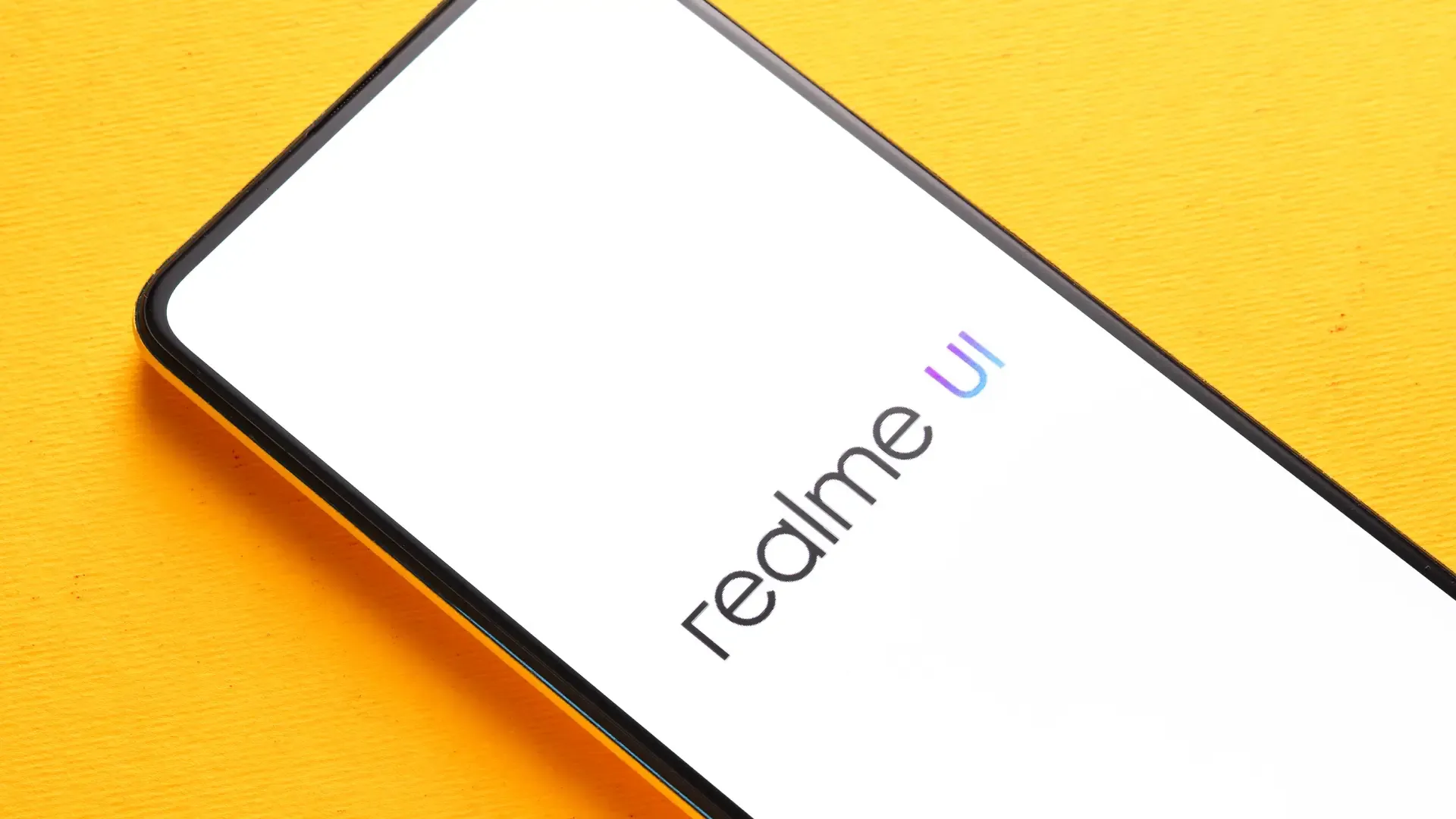 Um celular Realme está sobre uma mesa com a tela ligada