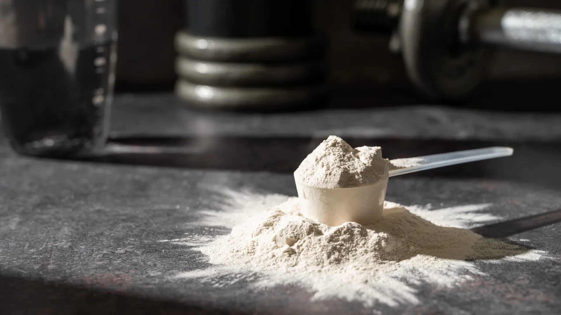 Suplementação, scoop de creatina em pó sobre bancada preta