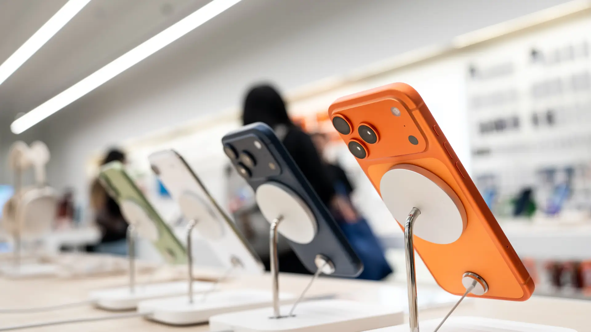 Vitrine de venda com vários celulares iPhones, cujo ângulo da foto mostra a parte traseira deles