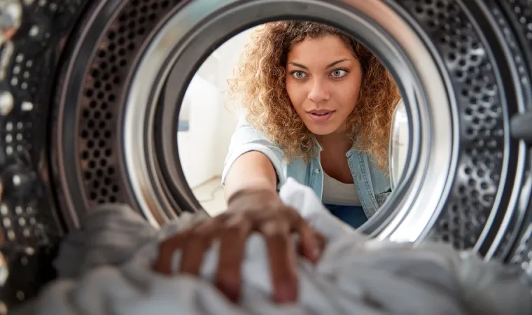 Mulher tirando roupas do tanquinho de lavar roupa 20kg.