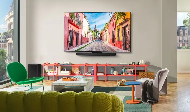 Imagem mostra a smart TV LG Evo C5 na parede de uma sala ampla