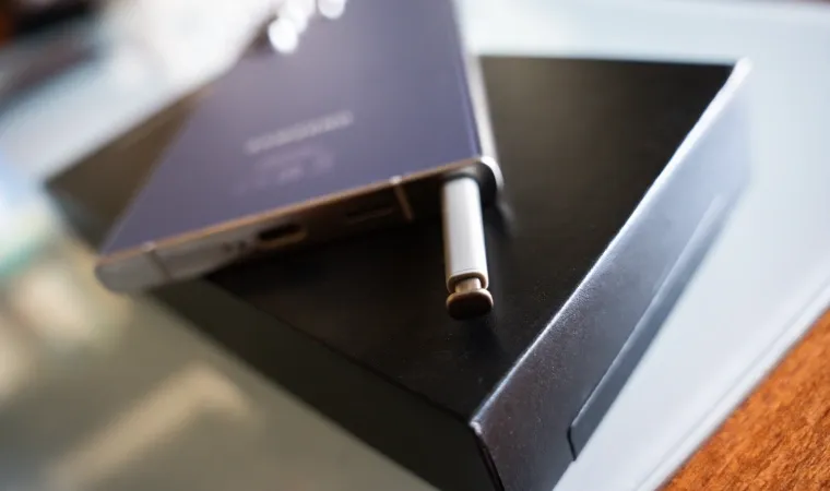 Imagem mostra detalhes de um celular com uma caneta