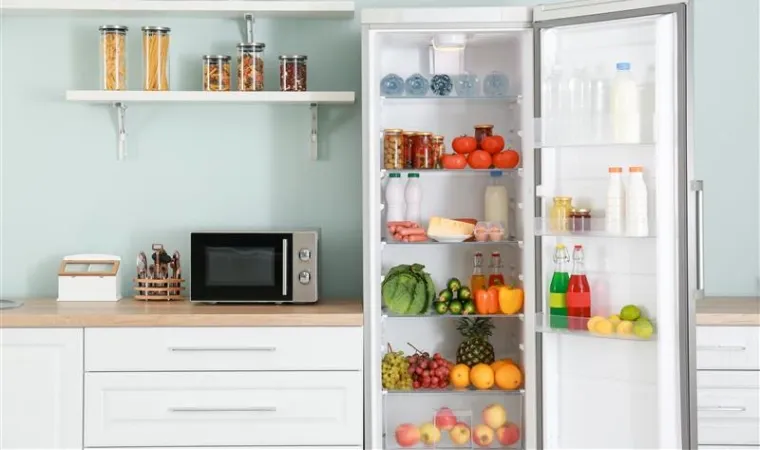 Geladeira branca de 1 porta com alimentos dentro