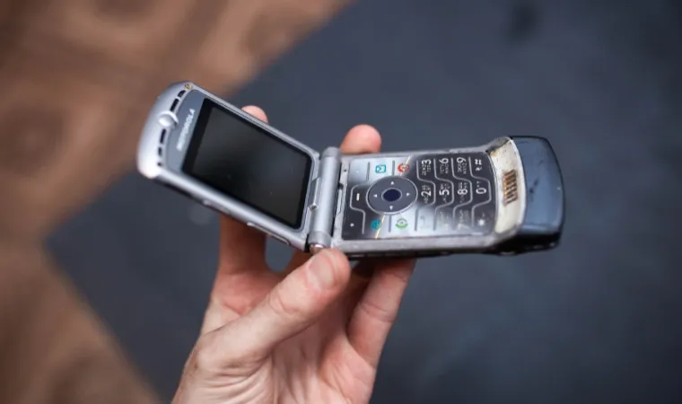 Foto de uma mão segurando um celular Motorola Razr V3 aberto  