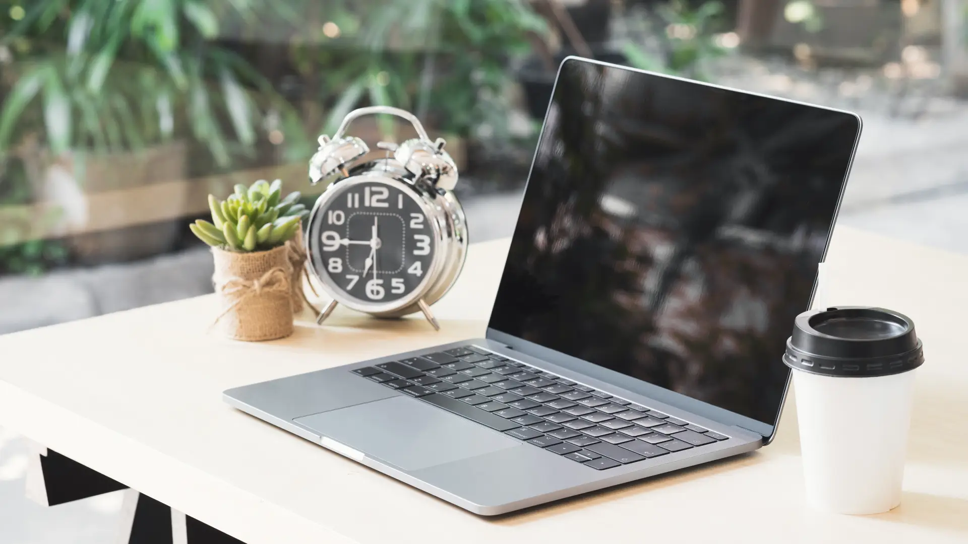 Imagem de um notebook com a tela aberta refletindo o ambiente ao seu redor