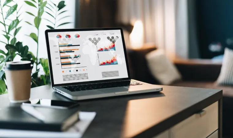 Foto de um notebook com gráficos, tabelas e diagramas sendo exibidos em sua tela