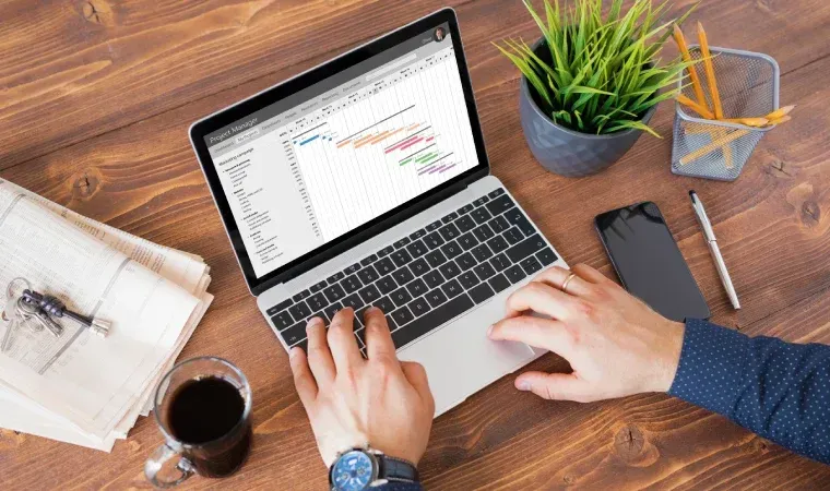 Imagem tirada de um ângulo de cima mostrando uma pessoa usando um notebook