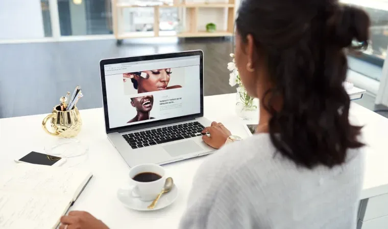 Imagem de uma mulher usando um notebook para trabalhar em uma peça de design para marketing