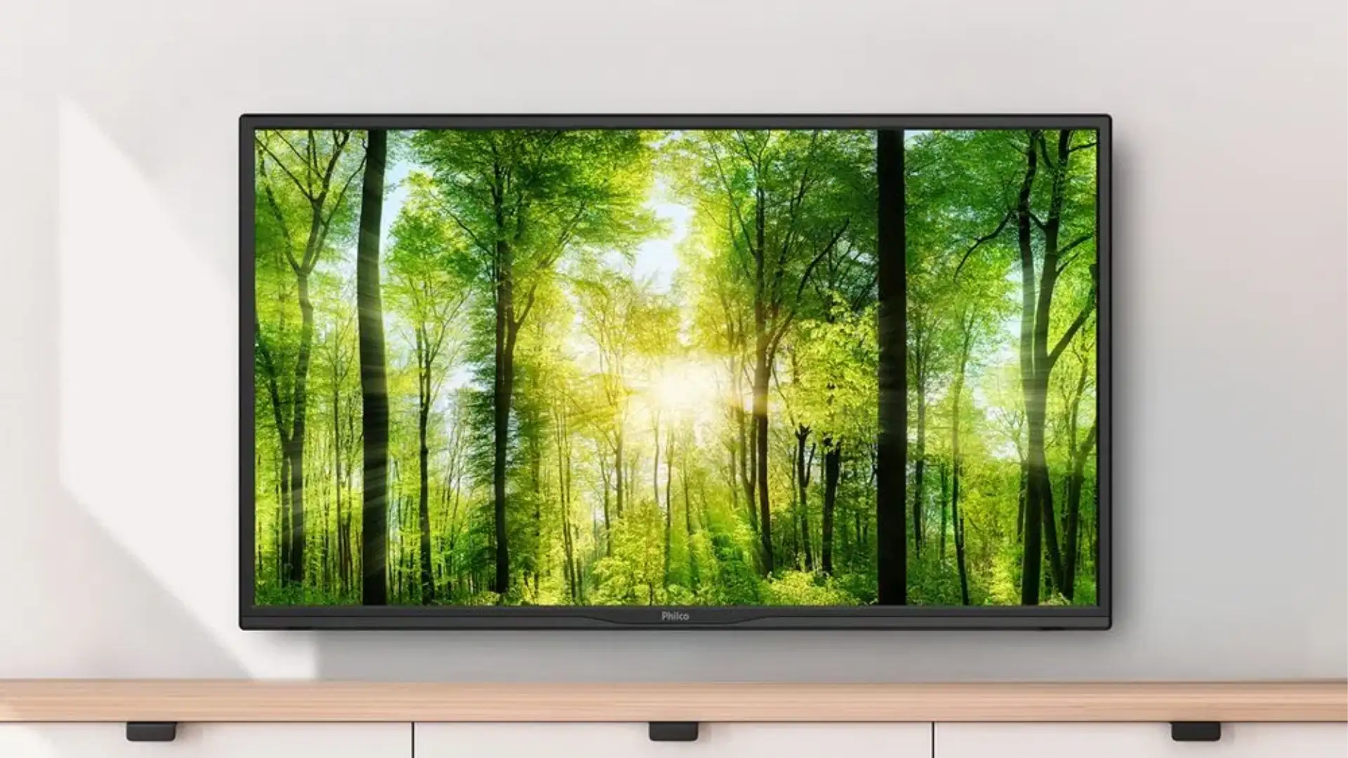 Smart TV Philco montada em uma parede, acima de um aparador