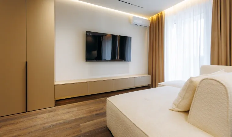 Imagem de um quarto com uma TV fixada na parede