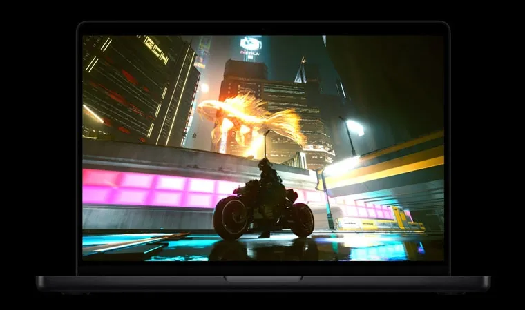 Imagem de um Macbook Pro com chip M5 padrão aberto rodando o game Cyberpunk 2077 com uma imagem do protagonista V em uma moto em frente a uma carpa holográfica
