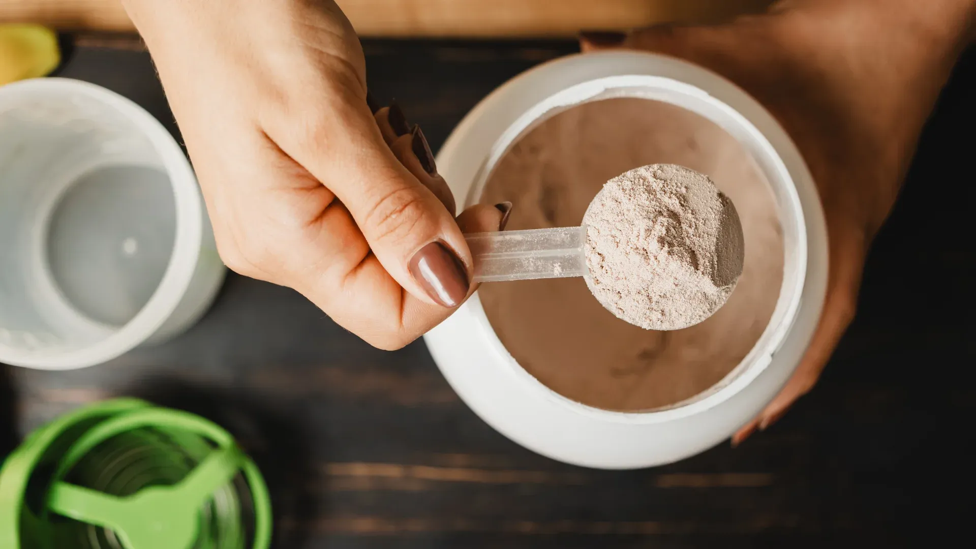 Imagem de um suplemento alimentar em pó, que poderia ser um whey protein, em uma mesa.