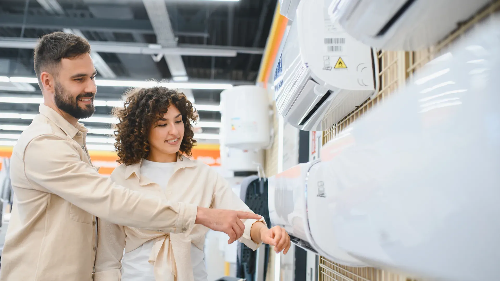 casal e loja de departamento analisando modelos de ar-condicionado Split