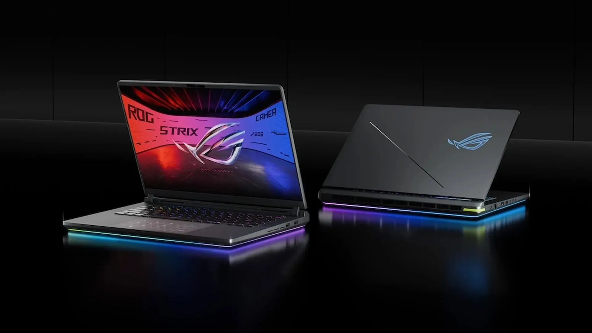 Dois notebooks ASUS ROG Strix G16 lado a lado, um com a tela aberta e outro com a tampa fechada, com o logo iluminado e a barra RGB