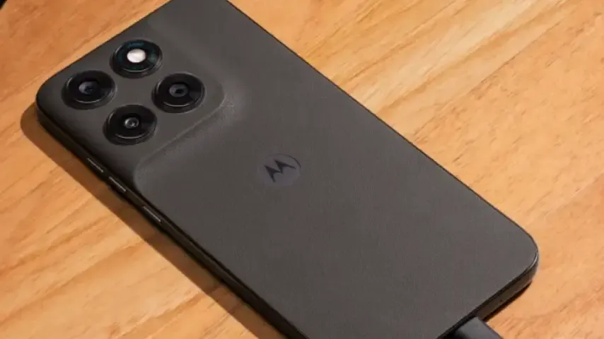 Smartphone Motorola sobre mesa de madeira conectado ao carregador USB-C