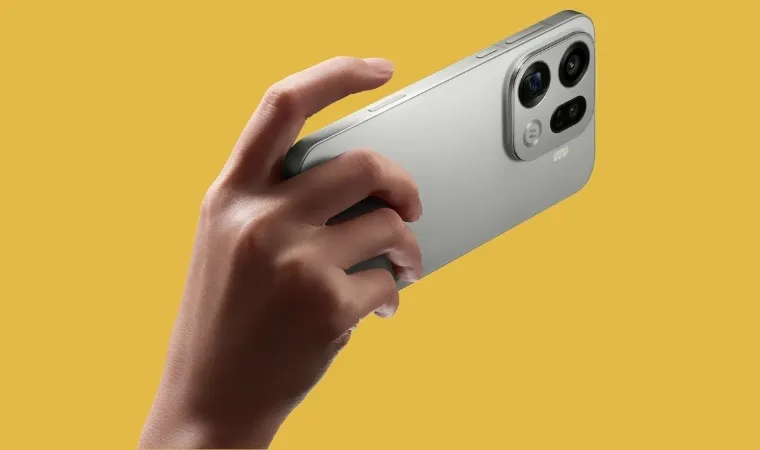 Uma pessoa segura um celular com apenas uma das mãos sobre um fundo de tela de cor amarela