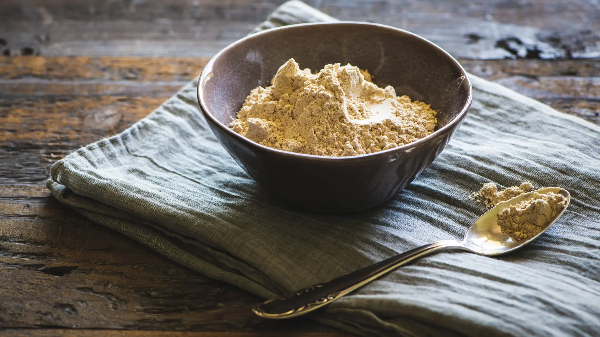 Um pote redondo com uma colher ao lado com maca peruana