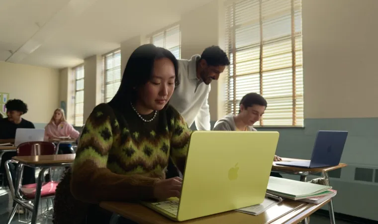 mulher usa MacBook Air cor citrus em um ambiente escolar.