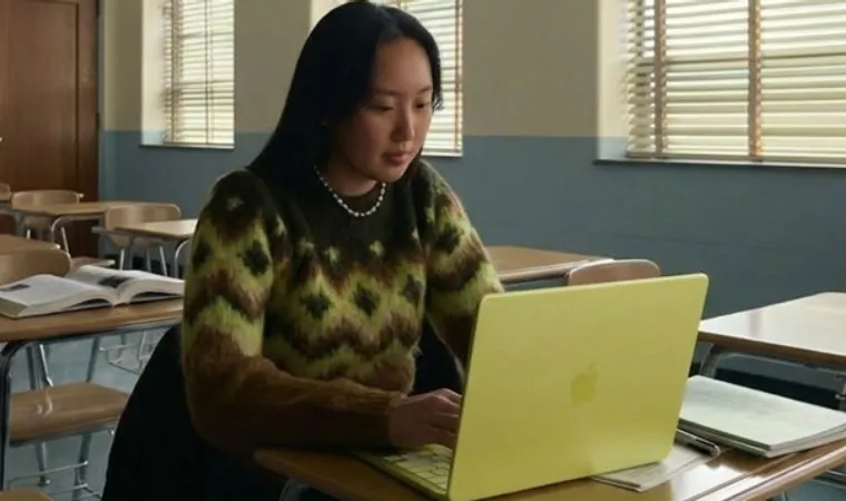 Foto de uma estudante usando um MacBook Neo na cor Amarelo-cítrico em uma sala de aula