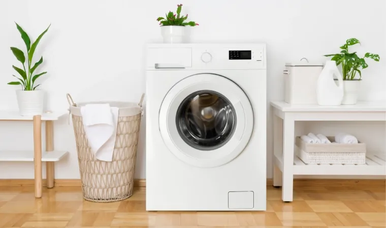 máquina de lavar front load em um ambiente bem iluminado e com objetos de lavanderia ao lado